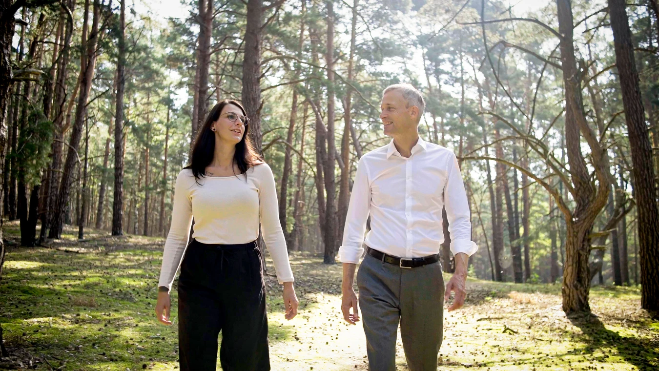 Chefarzt im Gespräch mit Patin bei gemeinsamen Spaziergang im Freien