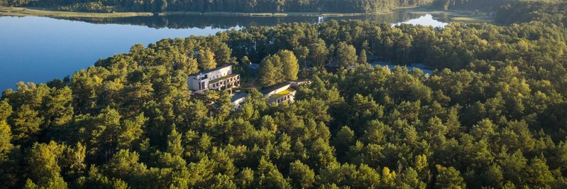 Luftaufnahme der Oberberg Fachklinik Berlin Brandenburg: Klinikgeb&auml;ude eingebettet in dichten Wald nahe eines Sees