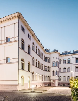 Moderne Au&szlig;enansicht der Oberberg Tagesklinik Frankfurt am Main &ndash; helles Geb&auml;ude mit gro&szlig;em Eingangsbereich, Glasfront im Vordergrund