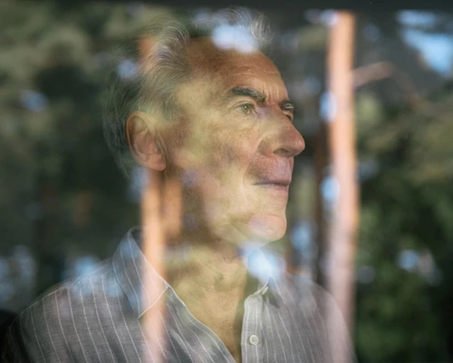 Mann schaut aus dem Fenster