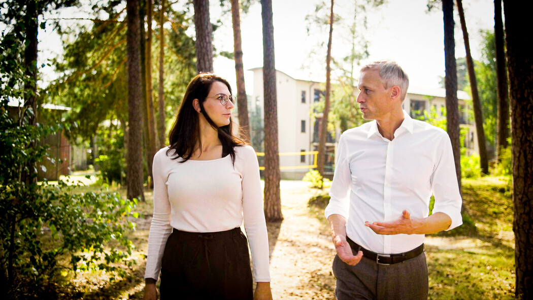 Zwei personen laufen drau&szlig;en im Park und unterhalten sich w&auml;hrend sonne scheint