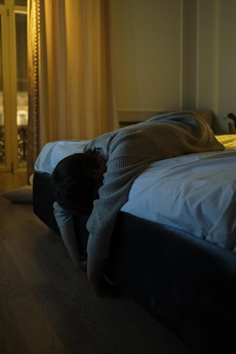 Peson liegt ersch&ouml;pft auf dem bett