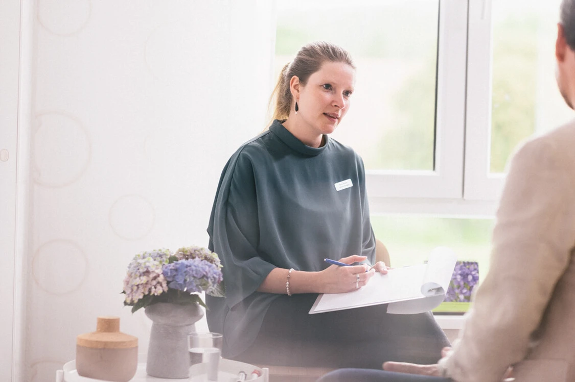 Frau spricht mit einem patienten