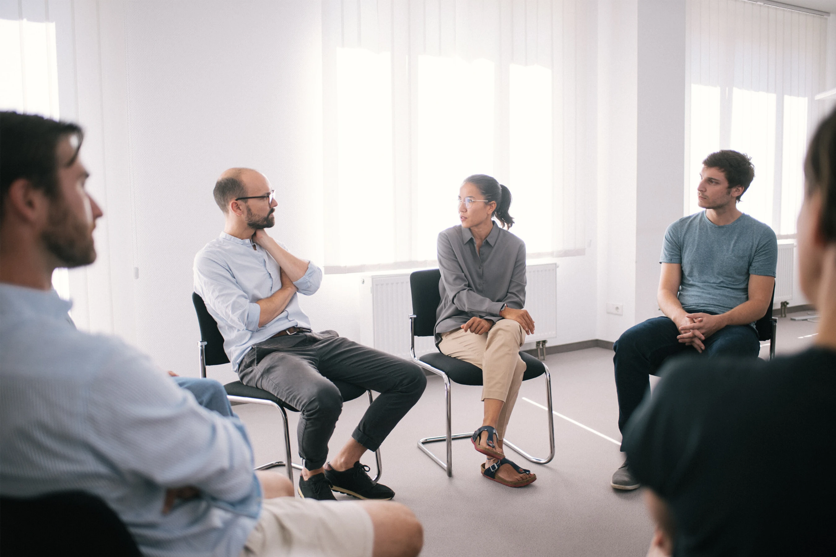 Eine Gruppe von Menschen in einem wei&szlig;en Therapie Raum