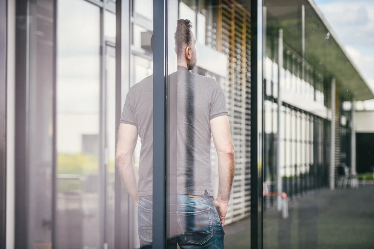 Mann steht mit Rücken zum Fenster