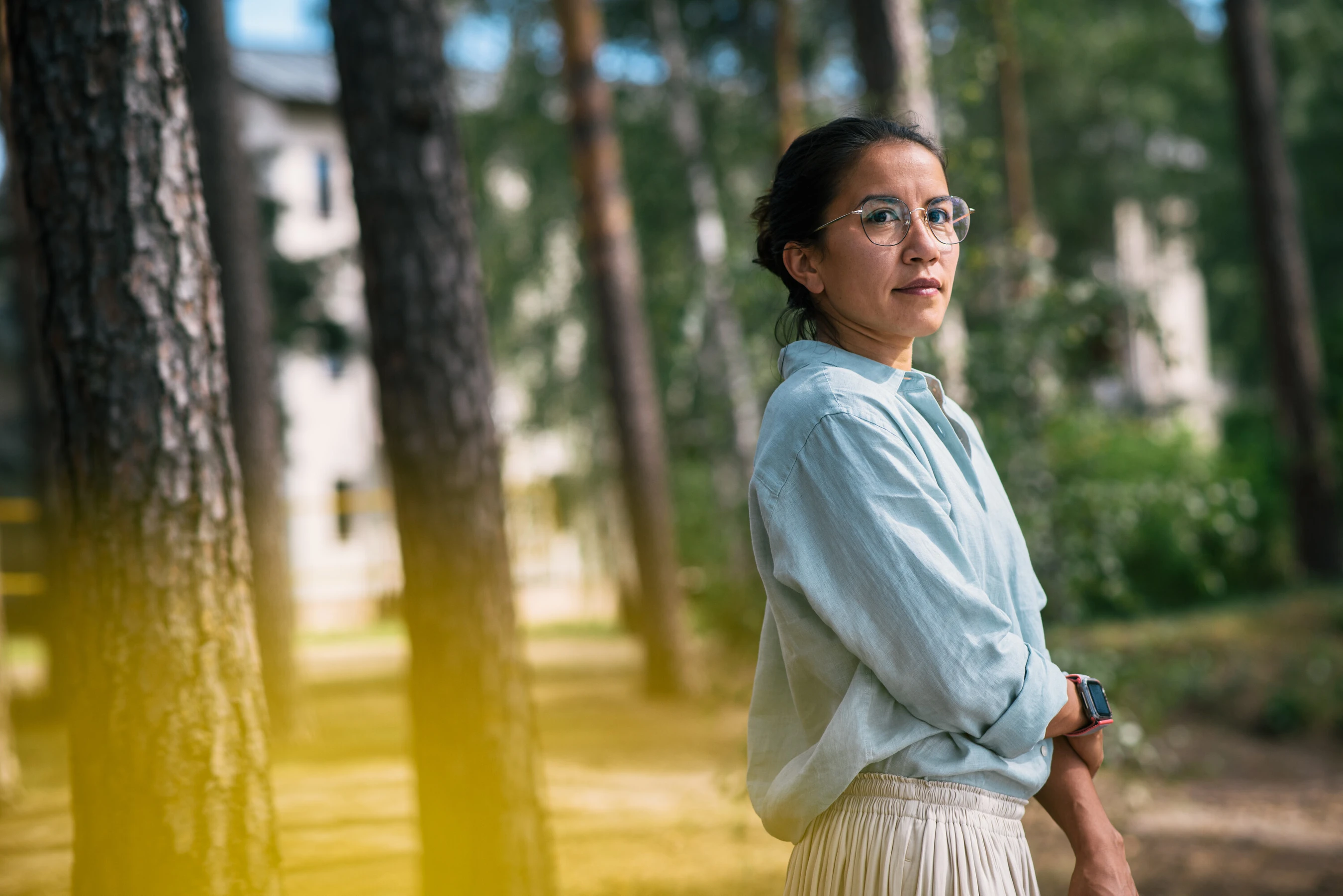 Frau steht drau&szlig;en und schaut richtung Wald