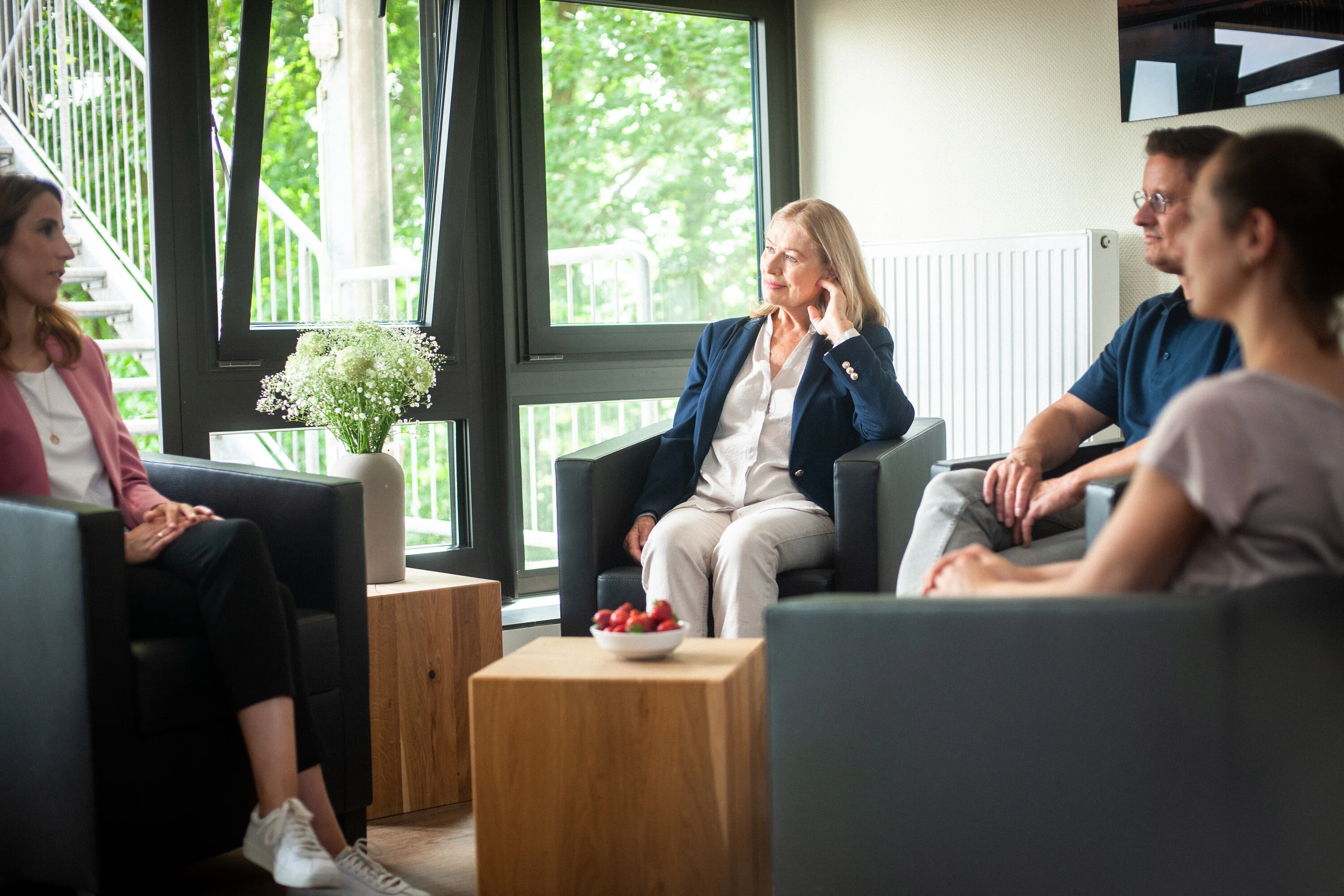 eine gruppe von menschen sitzt in einem raum und unterh&auml;lt sich