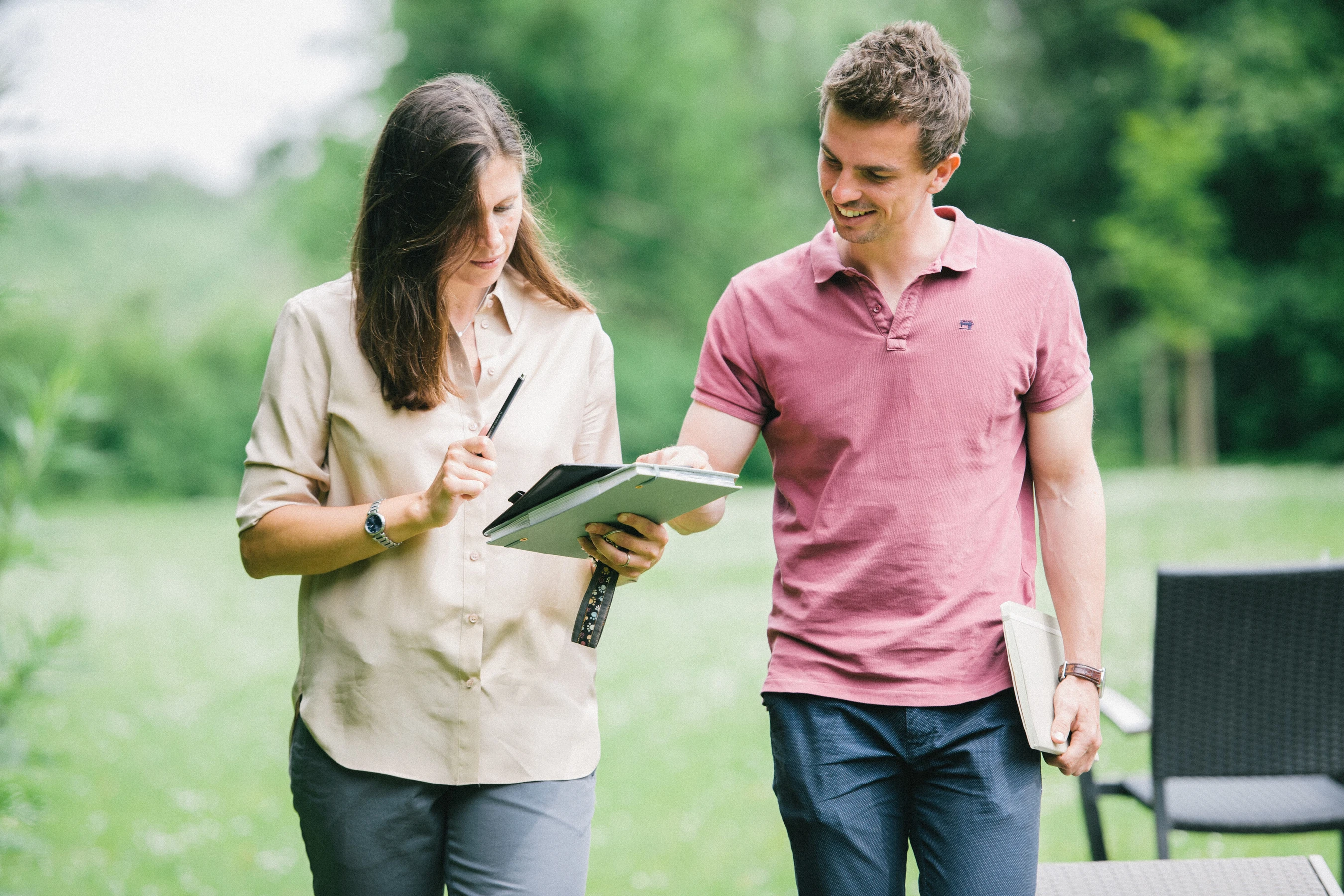 Ein mann und eine frau spazieren drau&szlig;en und schauen auf ein notizblock