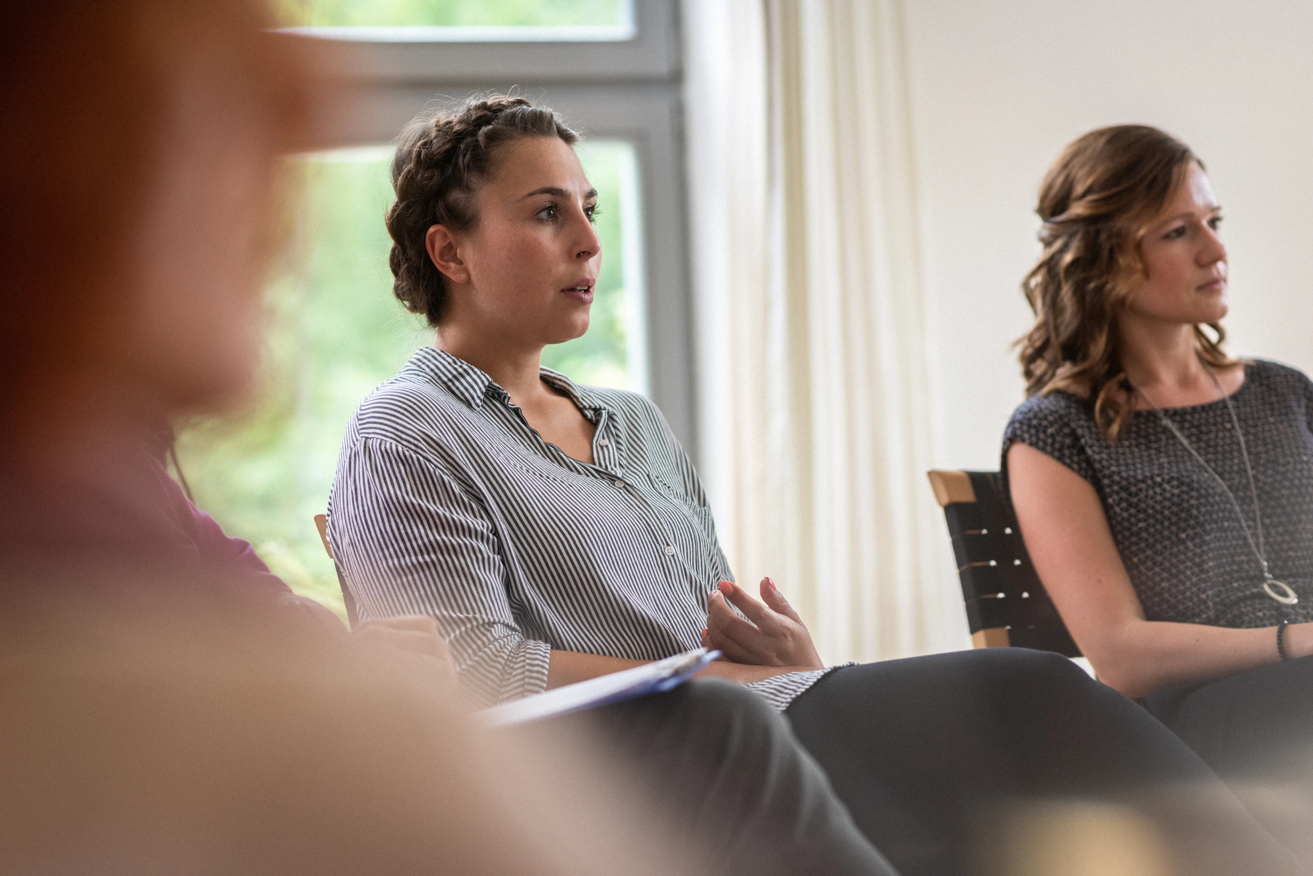 Frau sitzt in einer gruppe und spricht