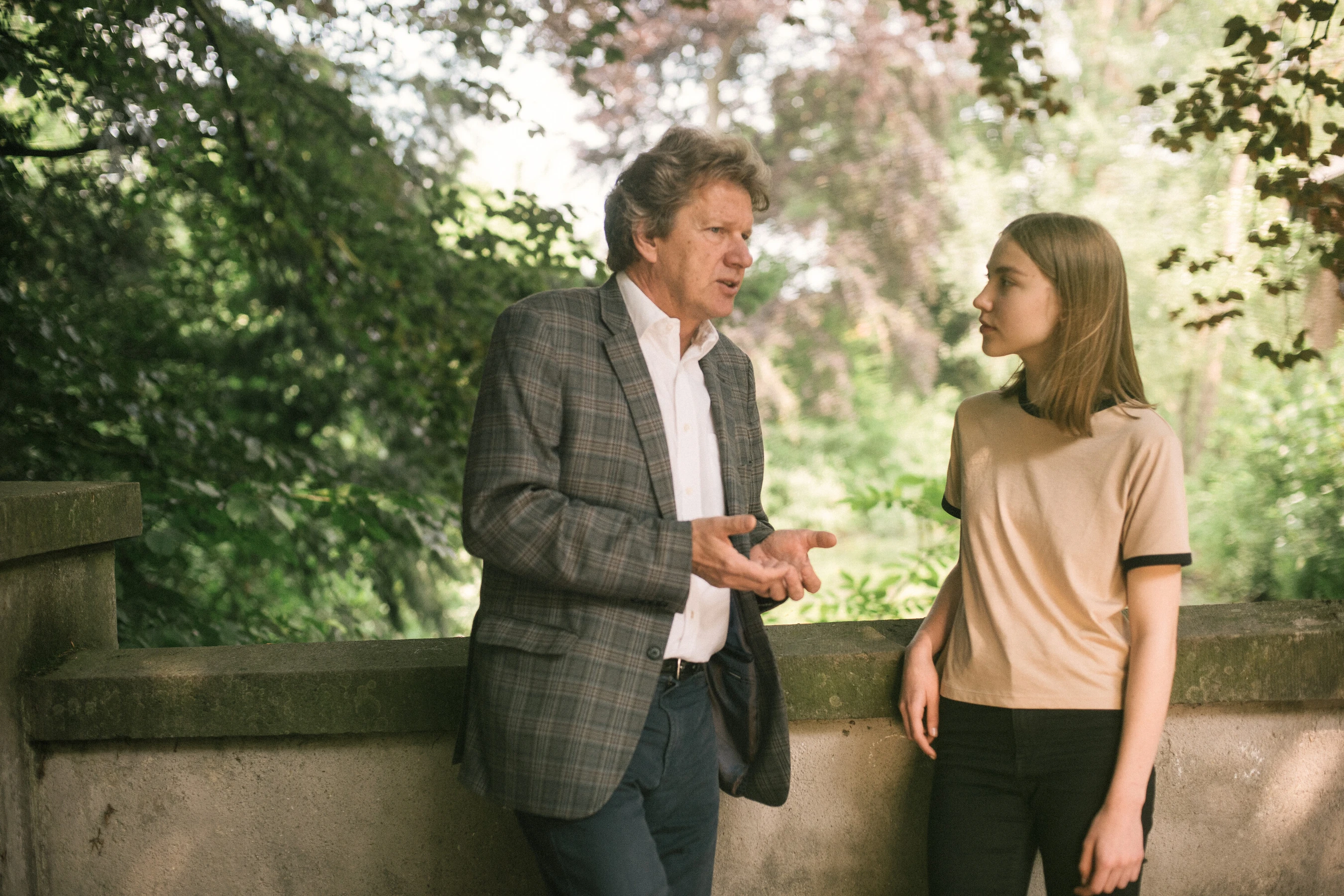 Mann spricht drau&szlig;en mit jungen M&auml;dchen